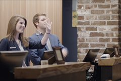 Male and female behind desk at hotel